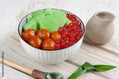 Bubur Campur Madura or Maduranese Mix Porridge, with Various Ingredient.rice flour, coconut milk, sweet potato balls, palm sugar syrup, and red sago pearl photo