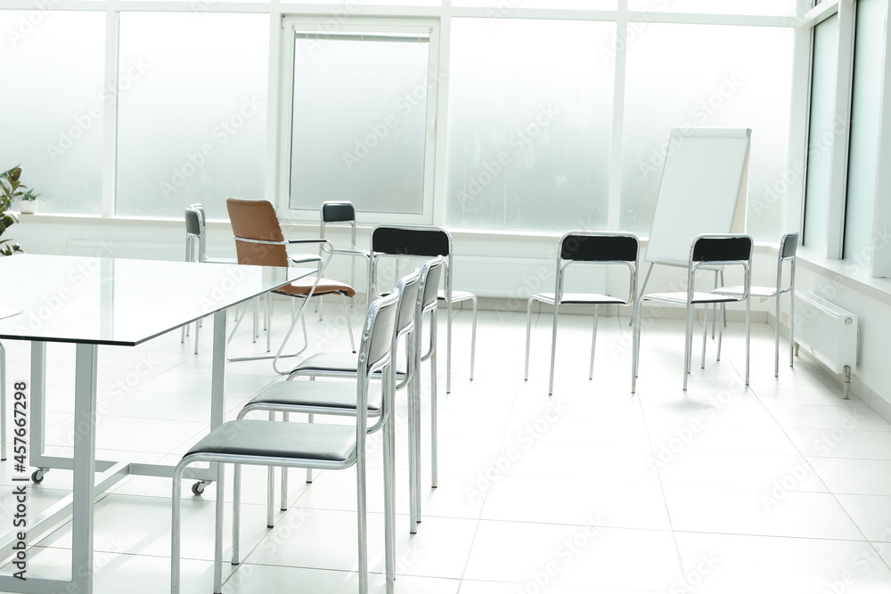 Flipchart chairs and glass table in a bright office space Flipchart chairs and glass table in a bright office space
