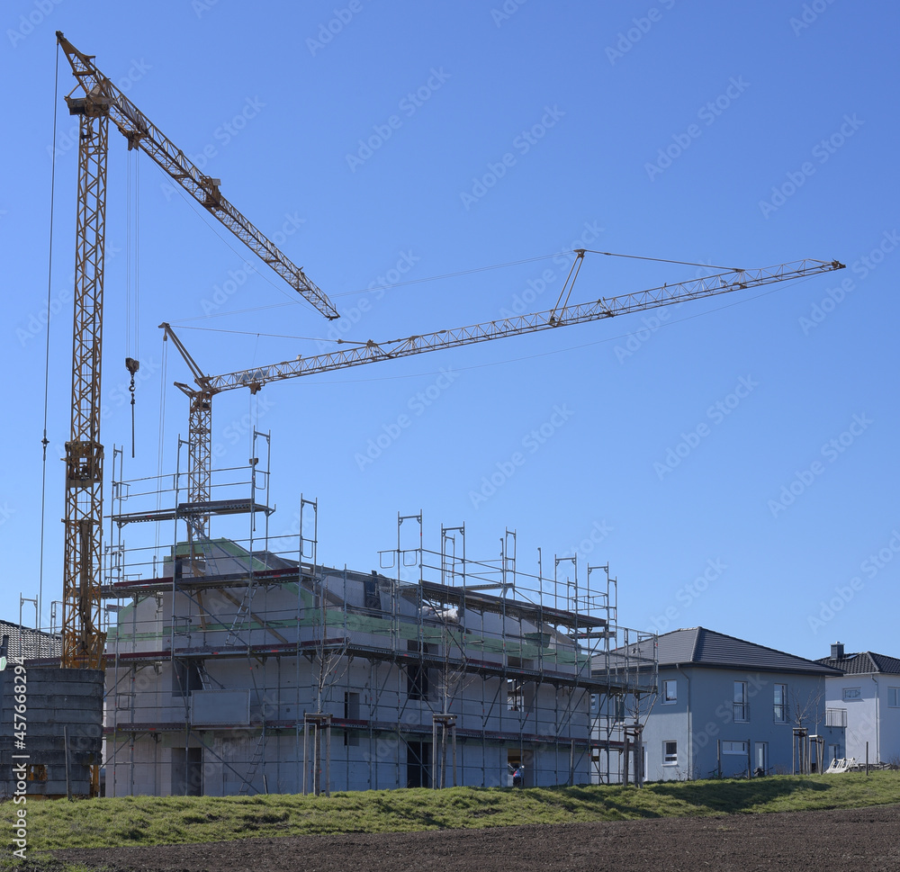 house under construction with cranes