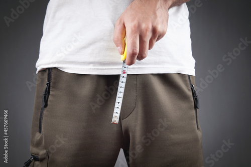 Foto Man with a measuring tape measures his penis size.