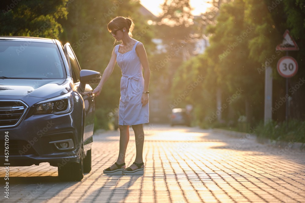 Young woman driver getting inside her car. Transportation and traffic concept.