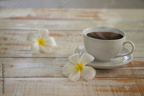 lumeria flowers with Espresso or americano, black coffee cup on a wooden floor. warm tone,