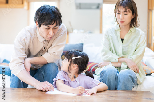 家でお勉強をする女の子と両親 © maroke