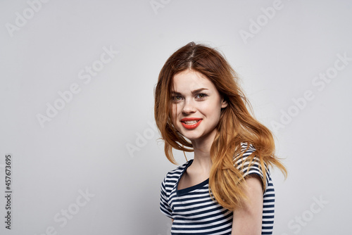 cheerful woman in a striped t-shirt gesture with his hands model studio