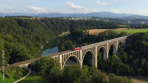 Aerial drone footage of a train crossing the famous Granfey viaduc, or bridge, over the Sarine river in Fribourg, Switzerland photo