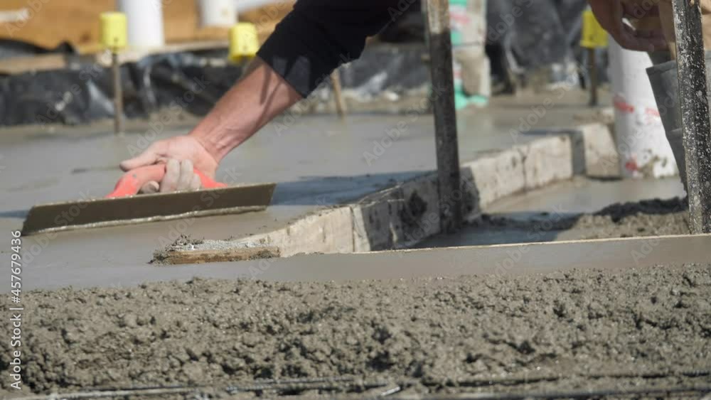 Wet Concrete Levelled By Construction Laborer With Handheld Trowel Wet Concrete Levelled By Construction Laborer With Handheld Trowel