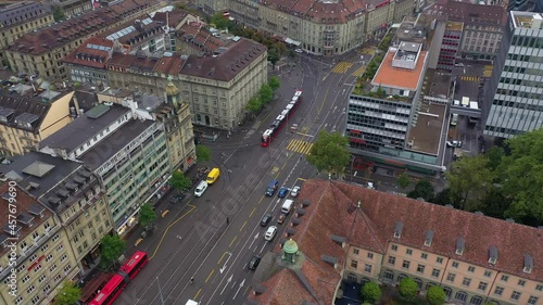 Aerial footage of Bern city center by the main train station with many tram cars in Switzerland capital city. The city has a ecological public transport system photo