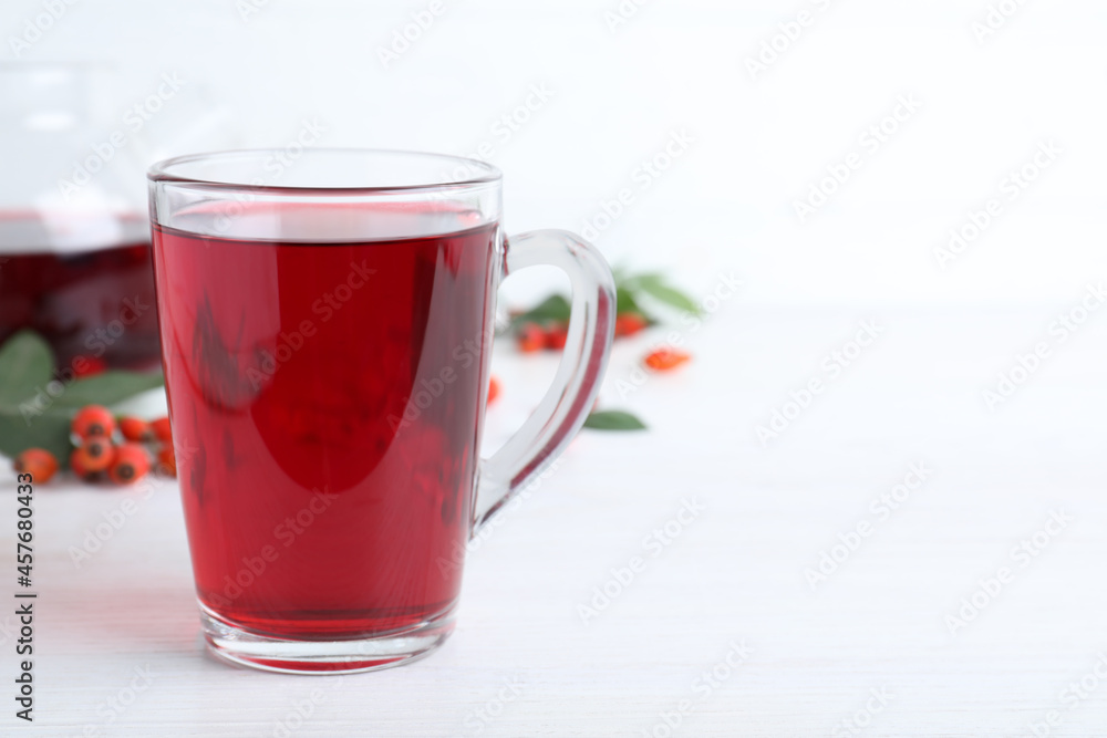 Aromatic rose hip tea and fresh berries on white wooden table, space for text Aromatic rose hip tea and fresh berries on white wooden table, space for text