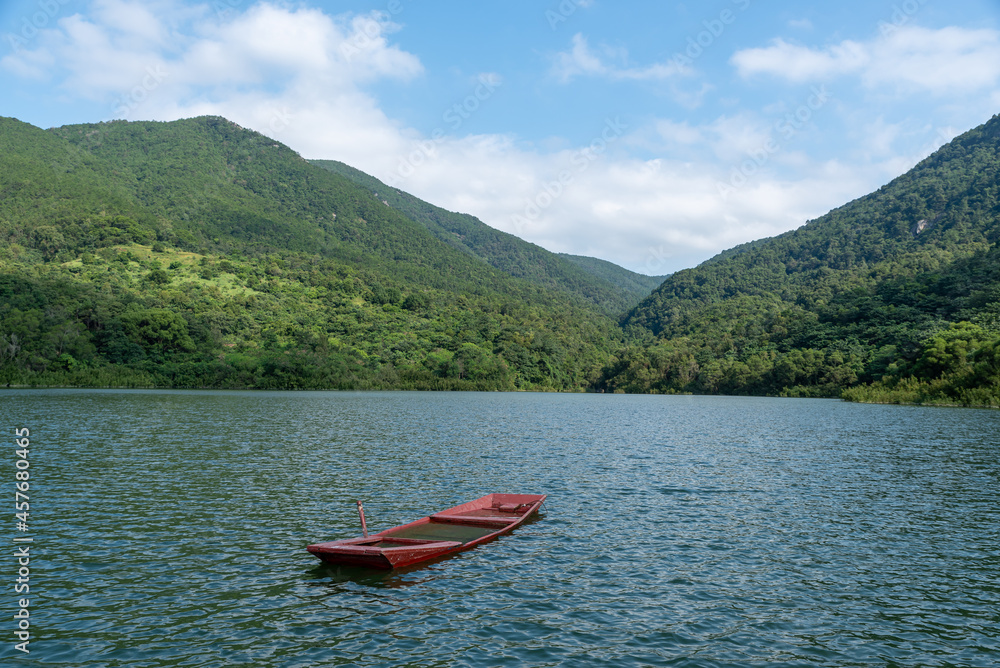 The scenery beside the reservoir is blue sky, white clouds, green mountains and clear water