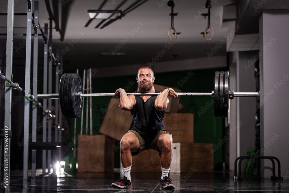 Naklejka premium Muscular athlete lifting very heavy barbell