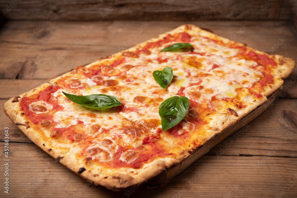 Homemade square pizza with cheese on wooden table