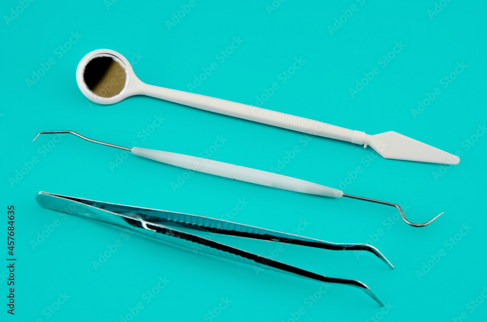 A set of dental instruments on a blue background. Minimalistic concept A set of dental instruments on a blue background. Minimalistic concept