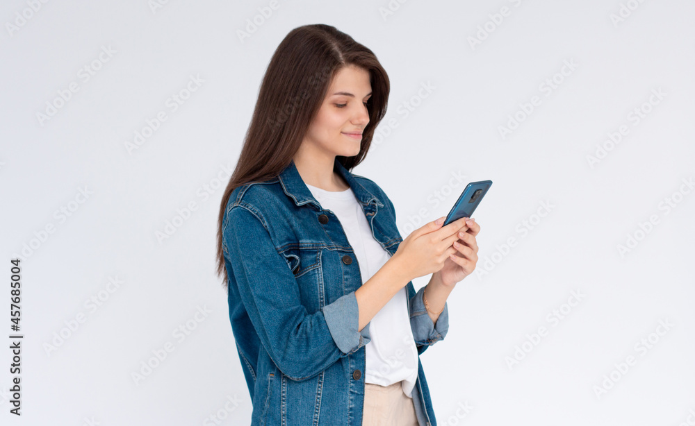 Pleased brunette woman writing message on smartphone over white background Pleased brunette woman writing message on smartphone over white background