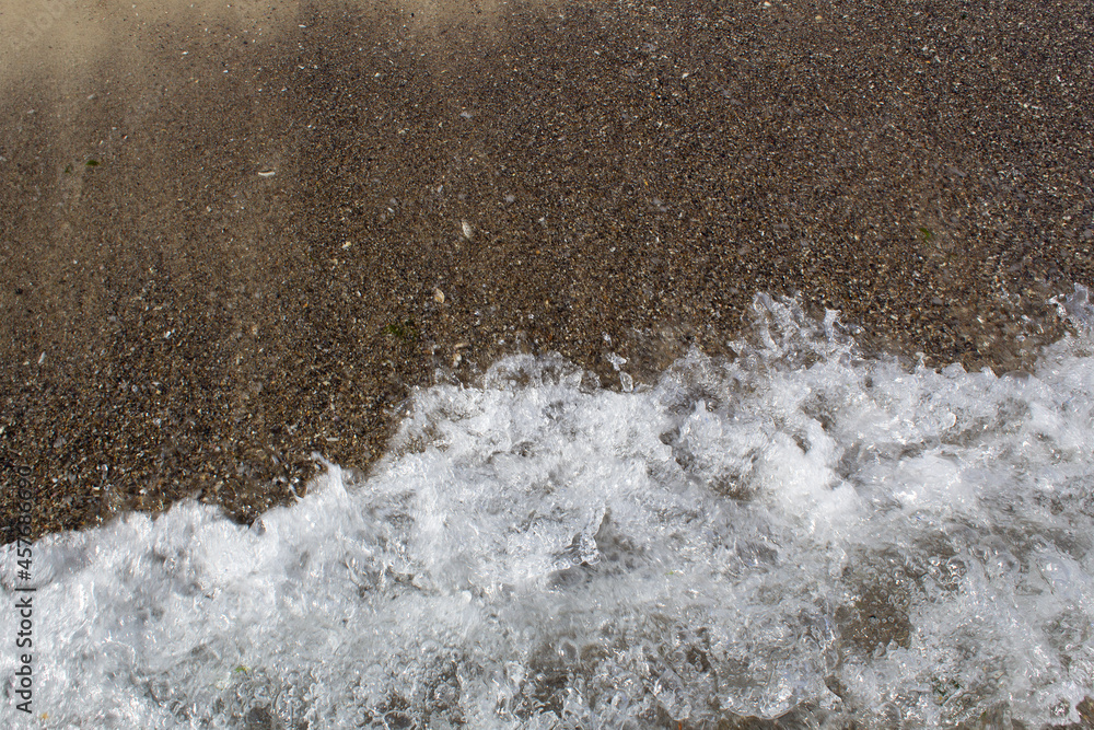 sea water wave splash on sandy beach surface top view sea water wave splash on sandy beach surface top view