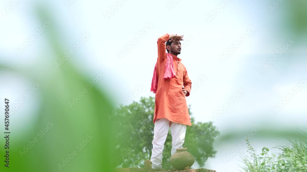 Indian farmer standing on bricks and watching on sky Indian farmer standing on bricks and watching on sky