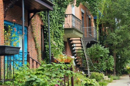 Street view of Montreal, Quebec, in Canada. Plateau Mont Royal neighborhood, one of the most beautiful in the city with colorful houses and greenery.