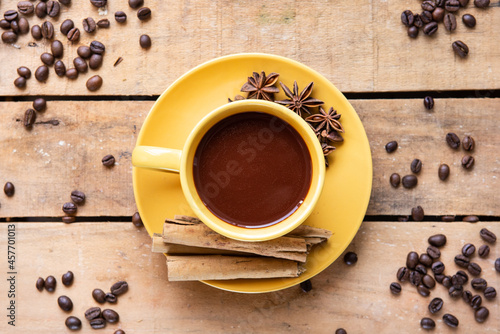 Top view of coffee cup with coffee beans on wooden table