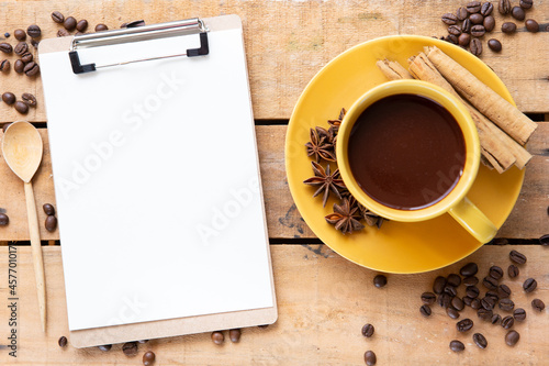 Top view of coffee cup on table with cliboard photo