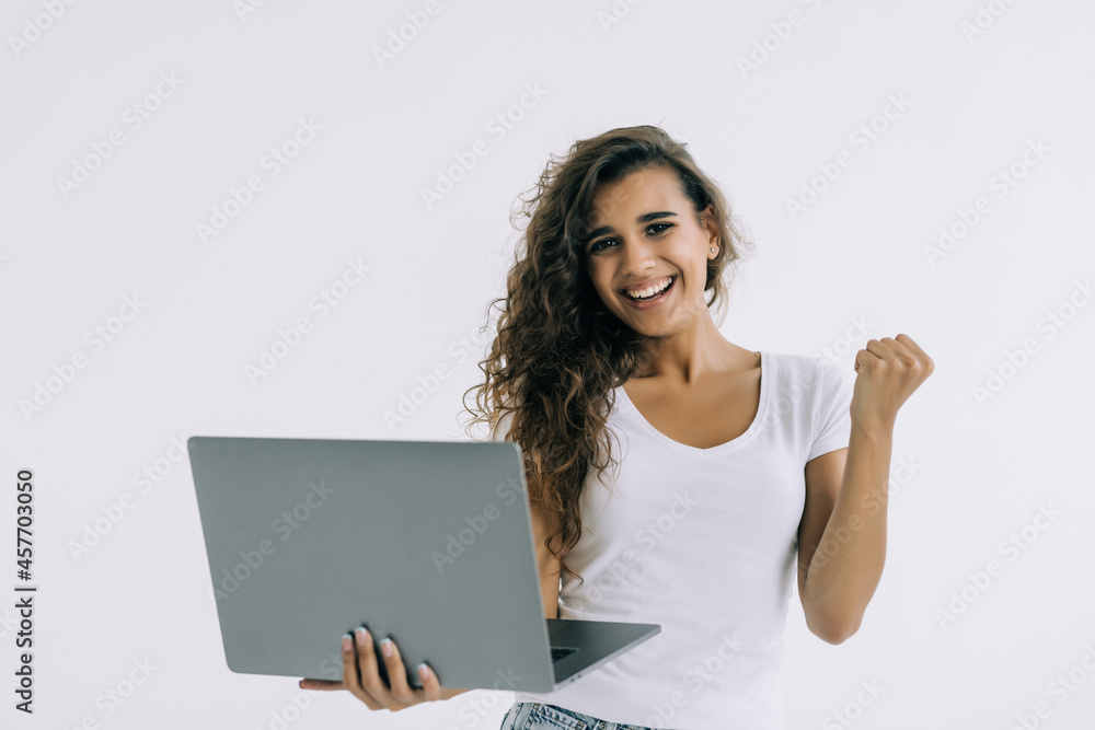 Successful woman with a laptop computer and arms up isolated over white Successful woman with a laptop computer and arms up isolated over white