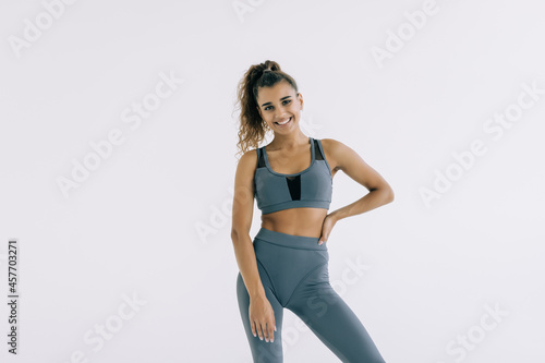 fitness woman in sport style standing against white background.