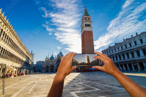 Canvastavla Tourist hands with a smartphone taking pictures of San Marco square in Venice, Italy