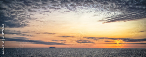 Sunrise in the English Channel near Dover with slightly cloudy sky us silhouette of a ferry boat photo