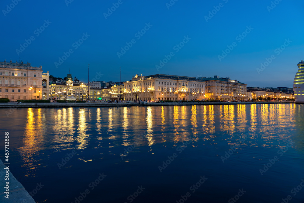 sea coast in Trieste Italy with beautiful illuminated buildings and reflection on the water