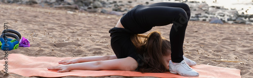 Girl gymnast trains on the beach by the sea. Photo series