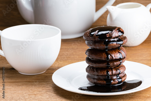 Closeup view stack of choco pie topped with chocolate syrup in white ceramic plate. photo