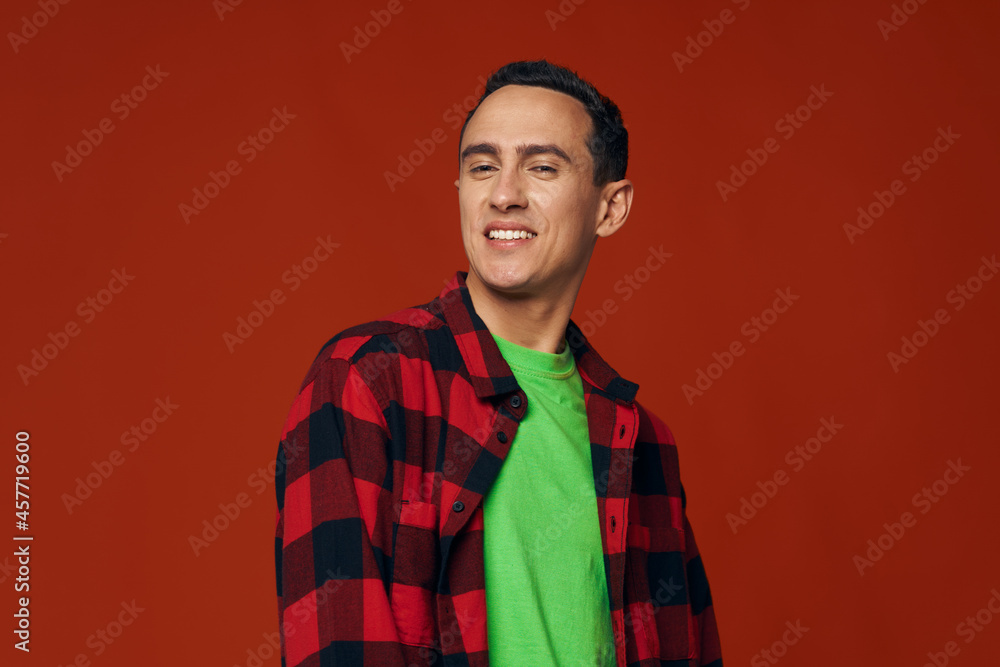 man in an unbuttoned shirt and in a green t-shirt on a red background smile model man in an unbuttoned shirt and in a green t-shirt on a red background smile model