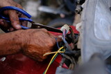 A technician is wiring during the electrical installation of a motorcycle.