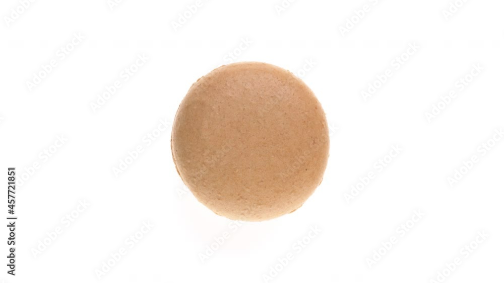 Top view of beige macaroon cookie rotating. Isolated on white background. Top view of beige macaroon cookie rotating. Isolated on white background.