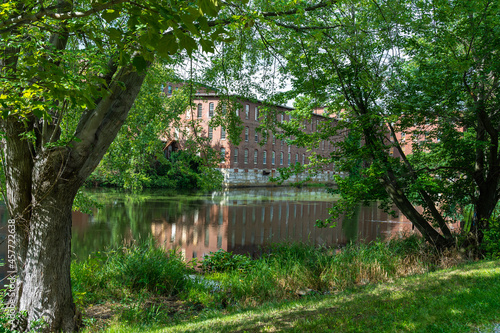 The Apartments At Cotton Mill along a graceful bend in the Nashua River in summer