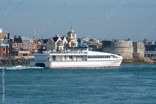Portsmouth, England, UK. 2021. A passenger catamaran ferry outbound from Portsmouth Harbour passing the Round Tower fortification.