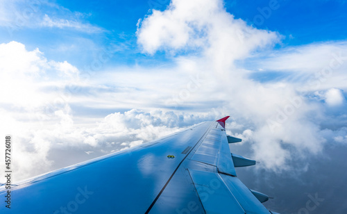 Stunning view through the window of an airliner flying above some fluffy clouds.