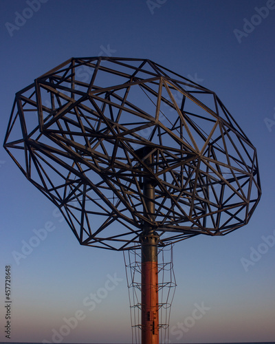 Аrt object metal brains against the background of the blue sky and sunset.