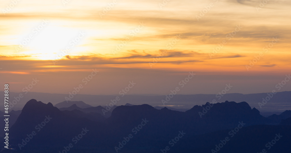 A panoramic landscape of mountain ridges with sunset sky and clouds at Phu Kra Dung National park of Thailand