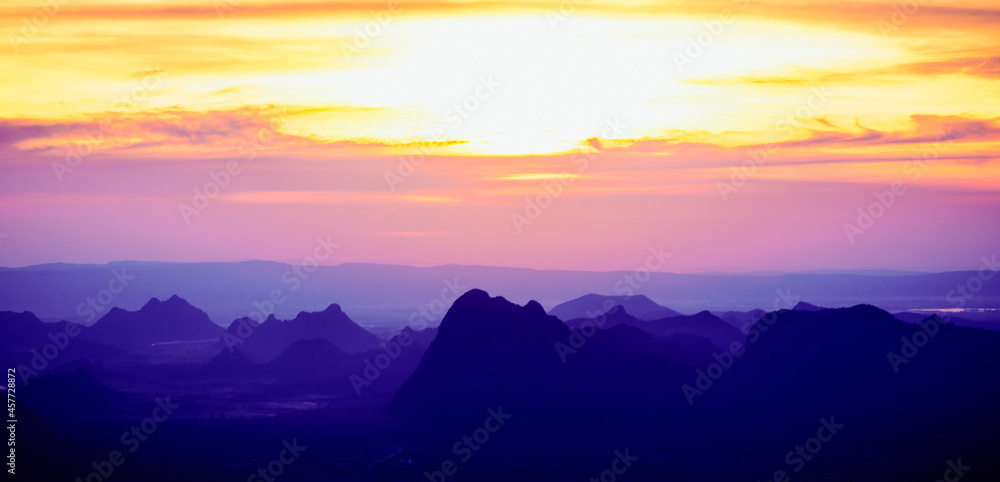 A panoramic landscape of mountain ridges with twilight sky and clouds at Phu Kra Dung National park of Thailand