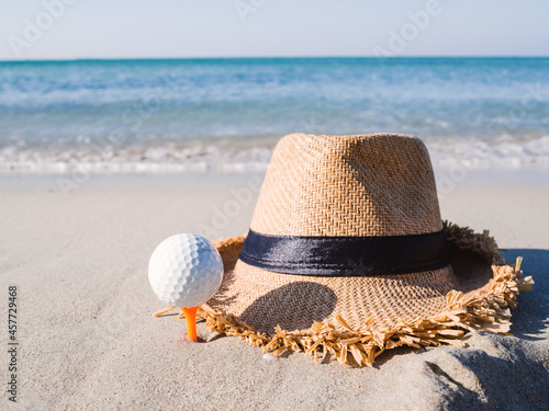 Hat on the sand beach the golf ball is on the tee embroidered, with the sea in the background