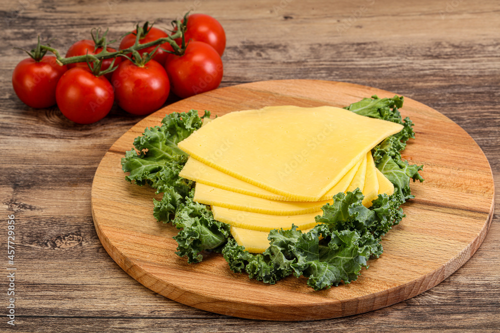 Sliced Gauda cheese over board Sliced Gauda cheese over board