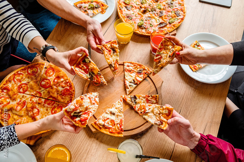 Group of people eating pizza.