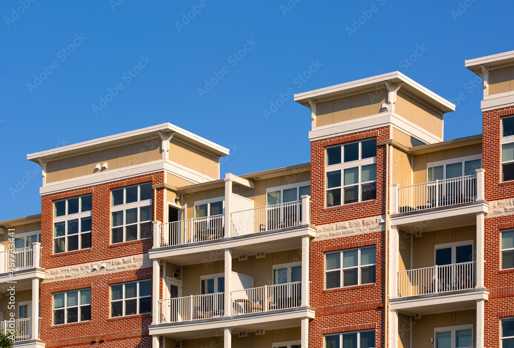 Generic apartment building exterior with blue sky; copy space