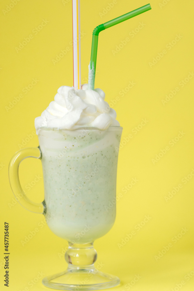 Cold green Peppermint milkshake on a yellow background Cold green Peppermint milkshake on a yellow background