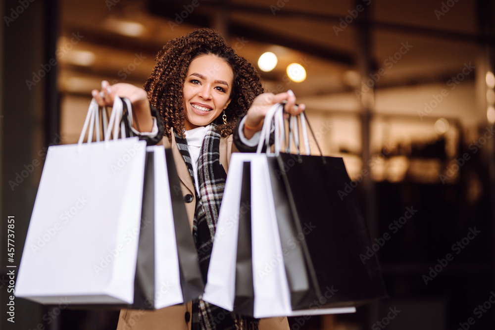 Autumn portrait of young woman with shopping bags near mall. Fashion, style, Black friday, sale, consumerism concept. Autumn portrait of young woman with shopping bags near mall. Fashion, style, Black friday, sale, consumerism concept.