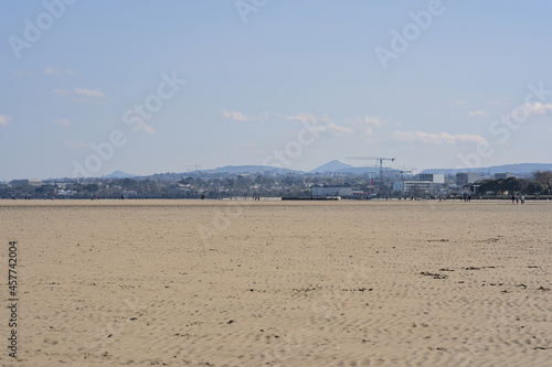 Beautiful bright view on South Dublin and the Mountains seen from Sandymount Beach, Dublin, Ireland during lowest tide. Walking people. Open spaces. High resolution