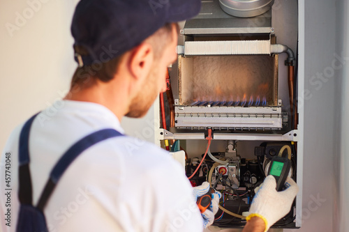 The master engineer maintains the gas heater. Adjusts the combustion of gas in the equipment photo