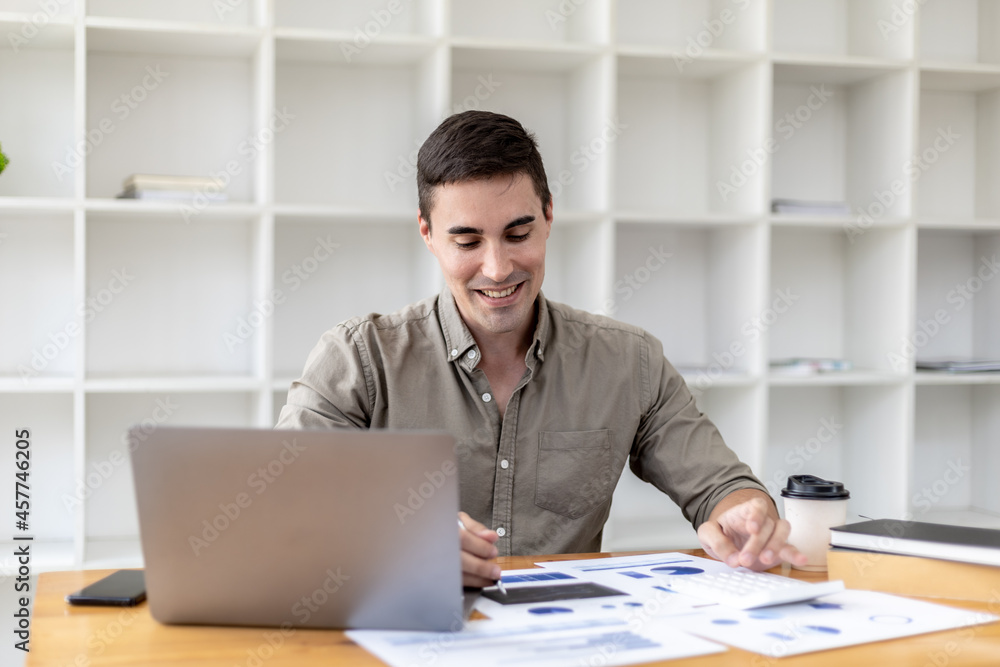 Young businessman sitting and checking financial documents displayed in chart format, young businessman who founded a startup company, managing a new business to grow by leaps and bounds. Young businessman sitting and checking financial documents displayed in chart format, young businessman who founded a startup company, managing a new business to grow by leaps and bounds.