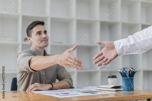 Cuadro en lienzo A young businessman is shaking hands with a business partner after a discussion