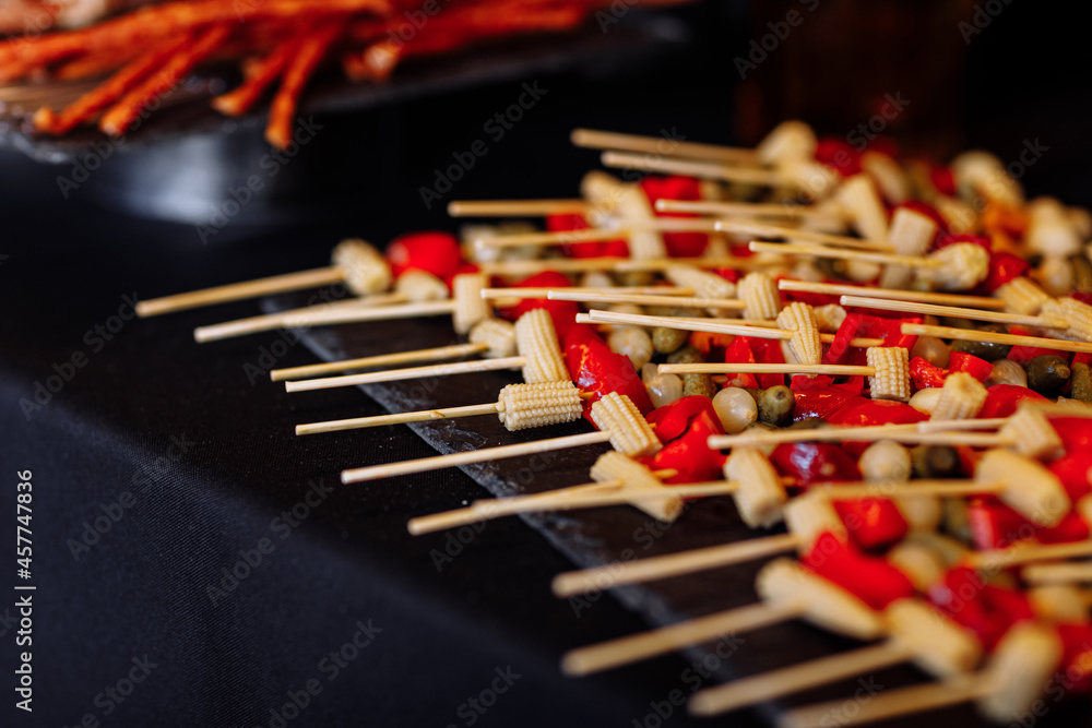 Naklejka premium black board with vegetables skewers on party holiday. selective focus.