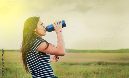 woman in the field drinking water, concept of woman in the field drinking water